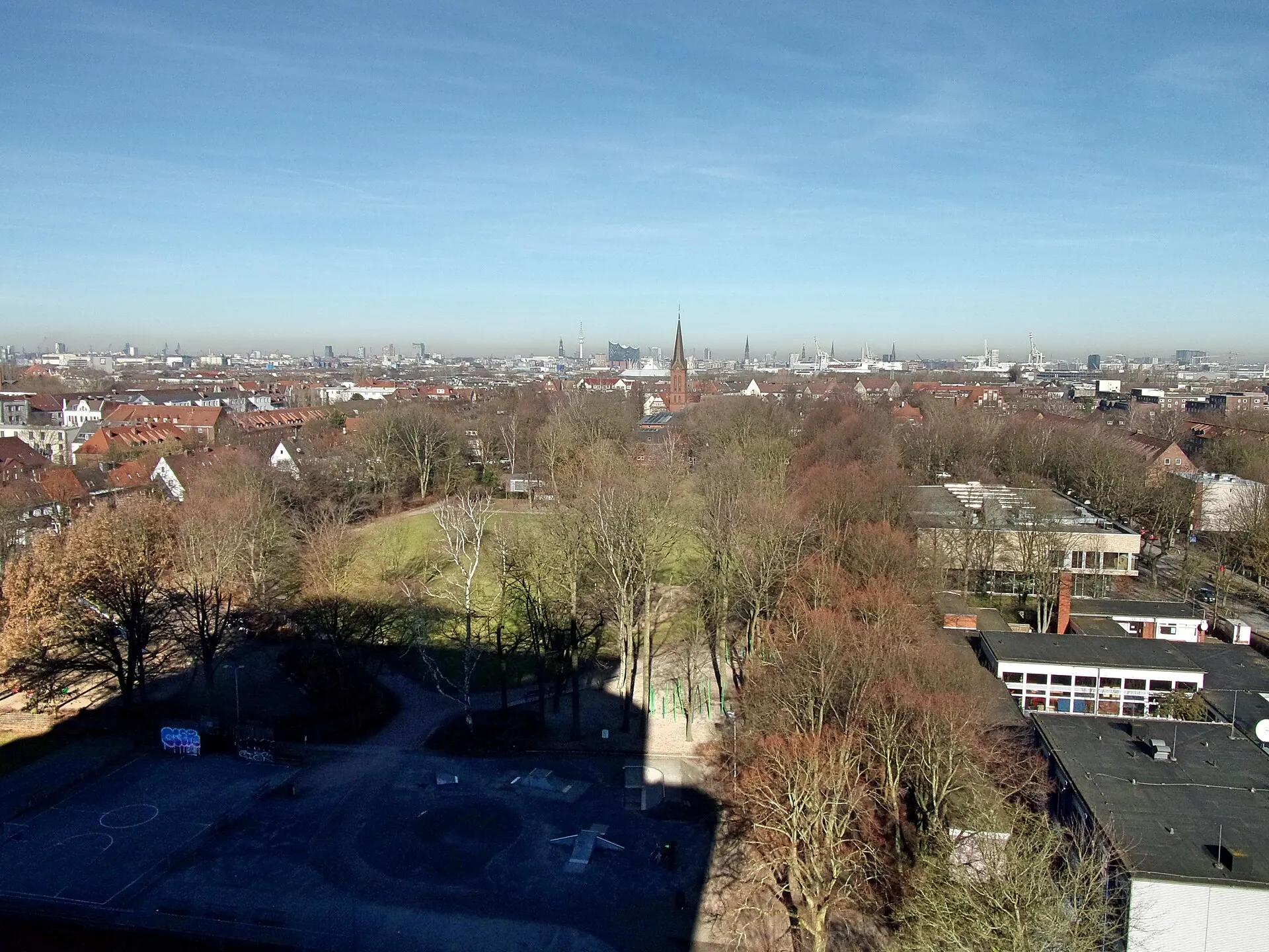 Blick vom Energiebunker in Wilhelmsburg in Richtung Norden; rechts das Haus der Jugend, in der Bildmitte der nördliche Teil der Grünanlage Rotenhäuser Feld, dahinter die Emmauskirche an der Mannesallee. Ganz hinten die…